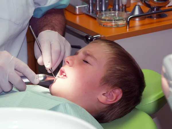 Мальчик под стоматологическим лечением — стоковое фото
