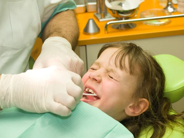 Девушка напряжена стоматологическим обследованием — стоковое фото