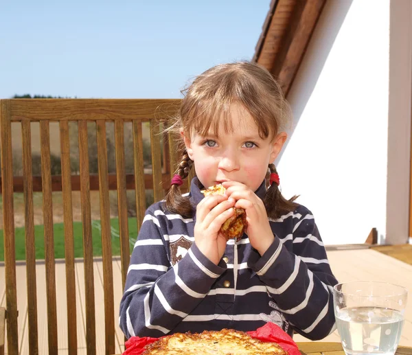 Девочка ест картофельные блинчики — стоковое фото