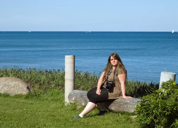 Kıyıda oturan genç bayan — Stok fotoğraf