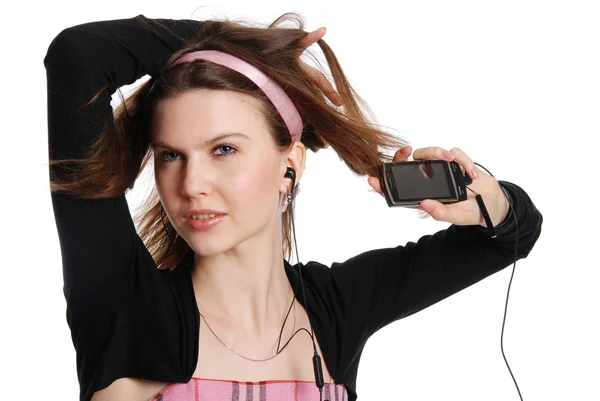 The girl with a cellular telephone listens to music in ear-phone — Stock Photo, Image