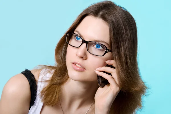 Piękna dziewczyna mówi o niebieskich oczach przez telefon — Zdjęcie stockowe