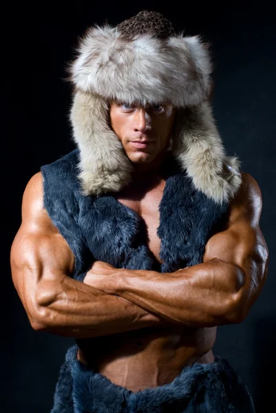 Strong athletic man in a fur cap — Stock Photo, Image
