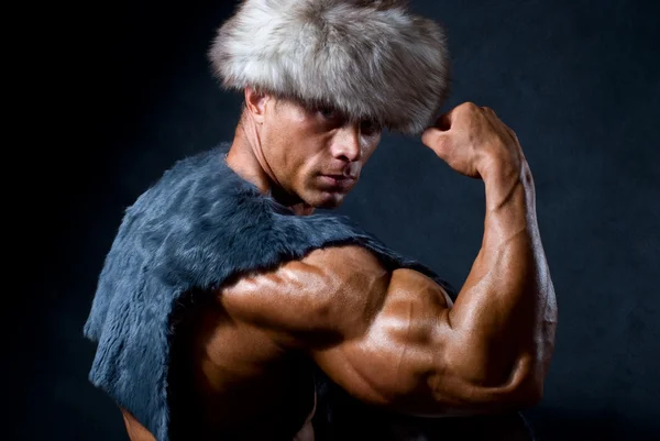 Strong athletic man in a fur cap — Stock Photo, Image