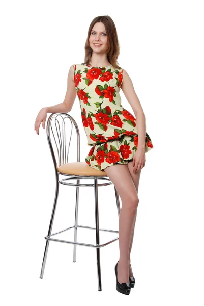 Den vackra flickan som står nära en stol — Stockfoto