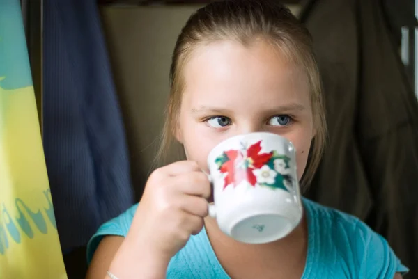 Девушка пьет из чашки — стоковое фото