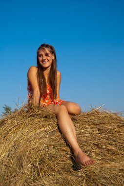 Happy girl on a haystack