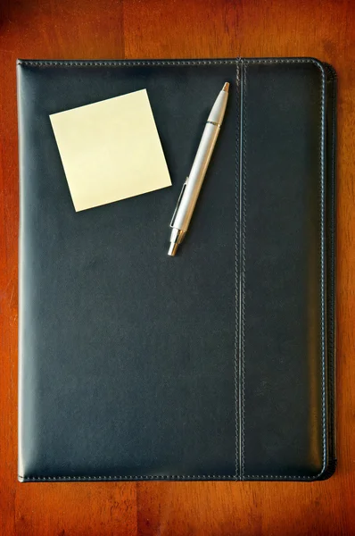 Исполнительная папка с запиской и ручкой — стоковое фото