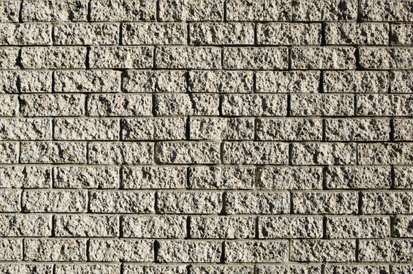 Grunge style brick wall with rough bricks in sunlight