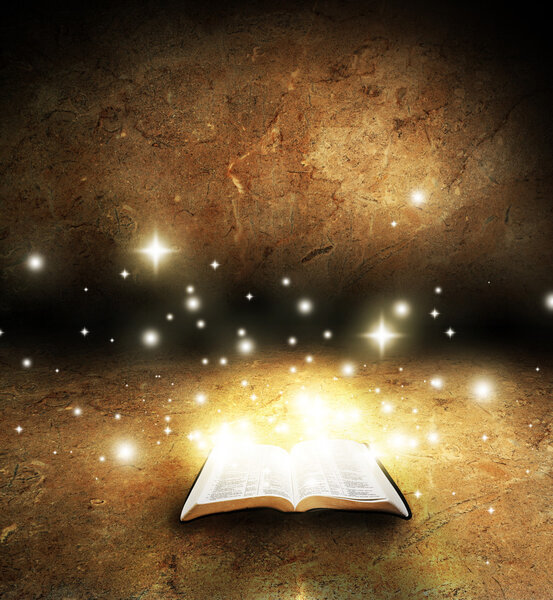 An open Bible with glowing lights and stars on an old textured background