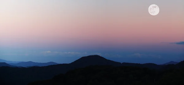 Montagne al tramonto con la luna piena — Foto Stock