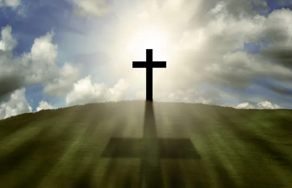 Kreuz leuchtet auf einem Hügel — Stockfoto