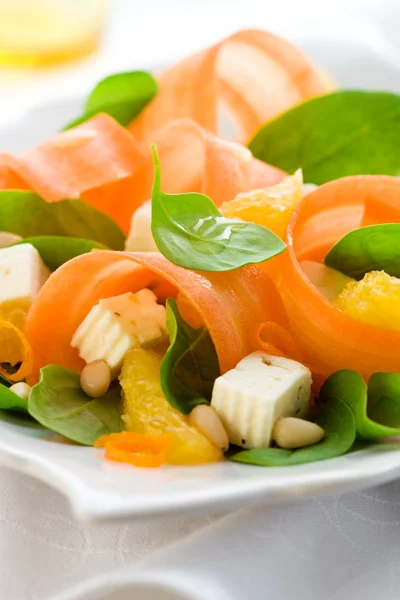 Mrkvový salát s listovým špenátem, sýr feta a oranžové — Stock fotografie