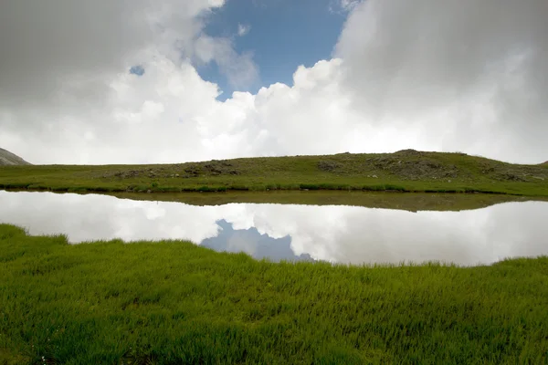 Lago de montaña con reflejo simétrico de nubes . — Foto de Stock