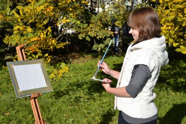 Charming artist in a park clipart