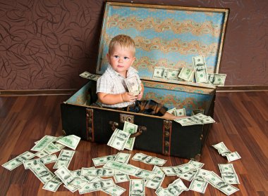 Cute little boy іs sitting in a suitcase with the money clipart