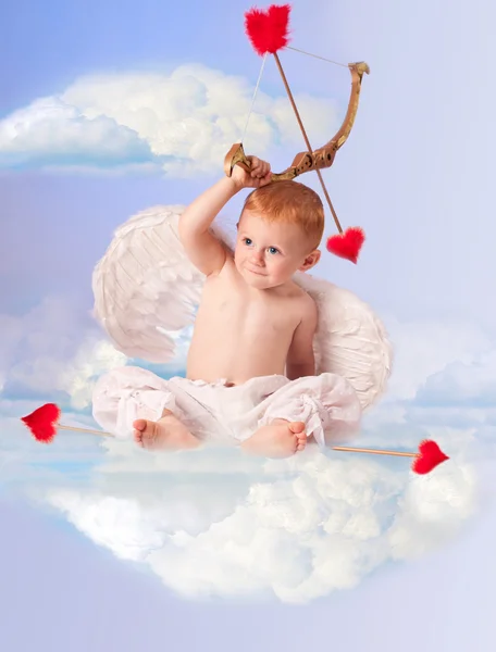 Милый ангелочек с луком и стрелами, сидящий на облаке — стоковое фото