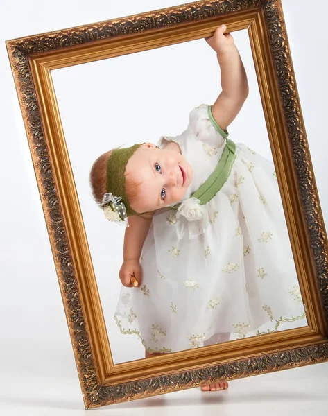 Портрет дівчини з рамкою. Маленька смішна дівчинка дивиться крізь фр — стокове фото