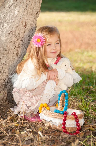 Beautiful little girl with a basket in anticipation — Stock Photo, Image
