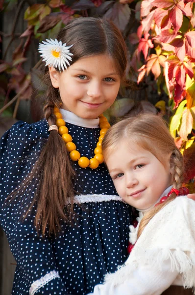 Twee leuke meisjes, zusters, permanent, bedrijf handen. — Stockfoto