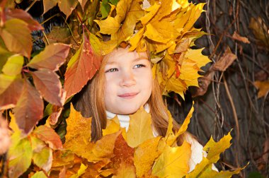 Cute smiling girl in a wreath of red viburnum on the head and with a bouque clipart