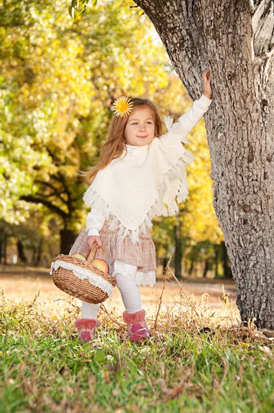 A little girl goes to the basket of apples — Stock Photo, Image