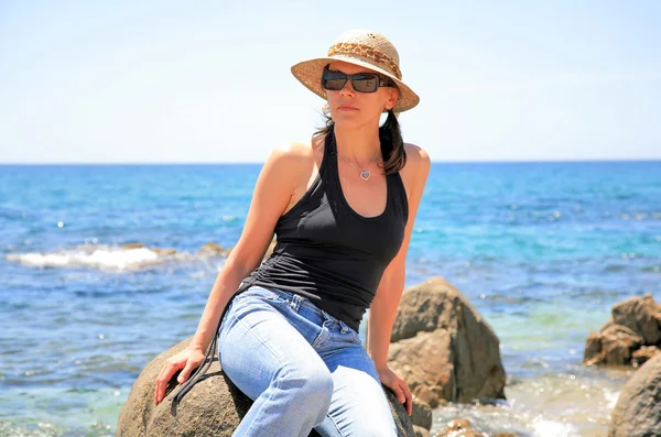 Giovane donna con occhiali da sole sullo sfondo del paesaggio marino — Foto Stock