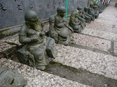 Japonya'da bir tapınağın merdivenlerde heykeller
