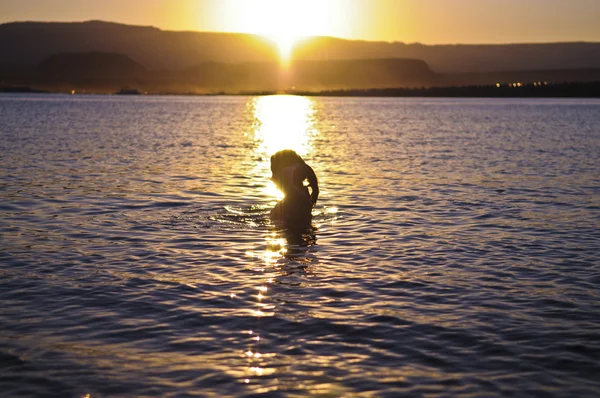 Дівчина купання на заході сонця — стокове фото