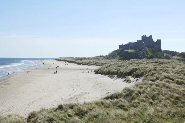 Bamburgh kasteel met zand duinen en de zee — Stockfoto