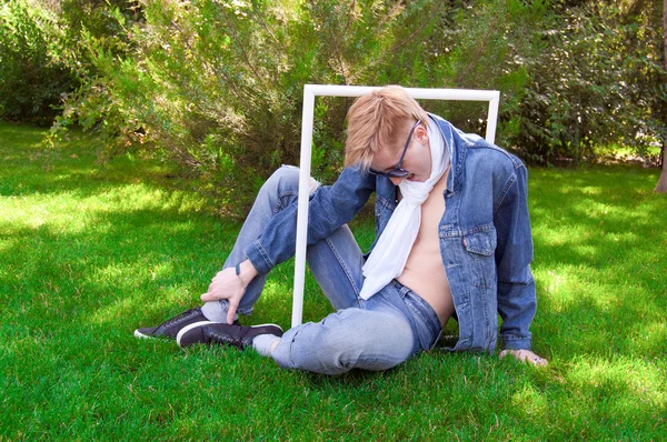 Jovem humano na grama verde com moldura branca — Fotografia de Stock