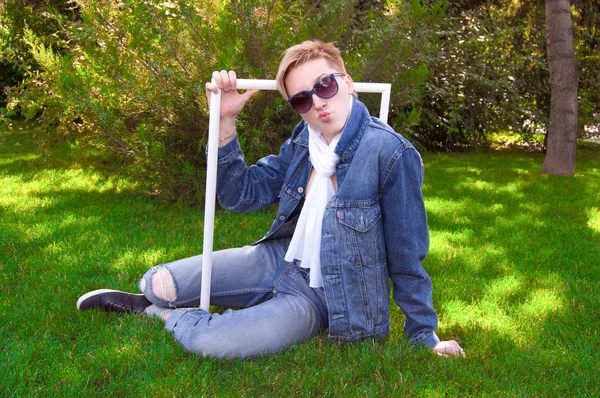 Jonge mens op het groene gras met wit frame — Stockfoto