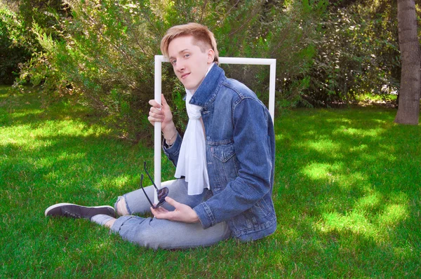 Jeune homme sur l'herbe verte avec cadre blanc — Photo