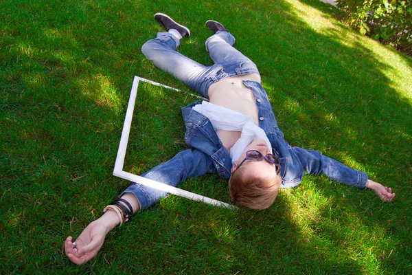 Młodego człowieka na zielonej trawie z białą ramą — Zdjęcie stockowe