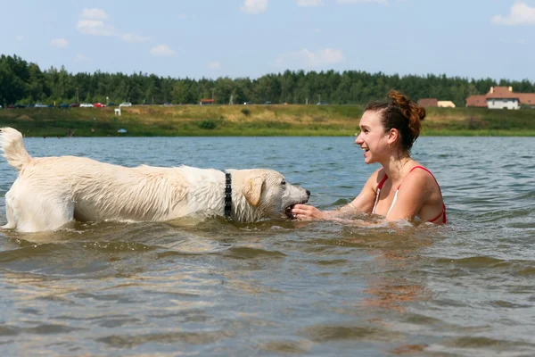 Chica con perro jugar en el agua — Foto de Stock