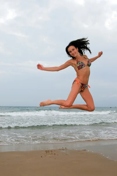 Kvinna hoppar på stranden — Stockfoto