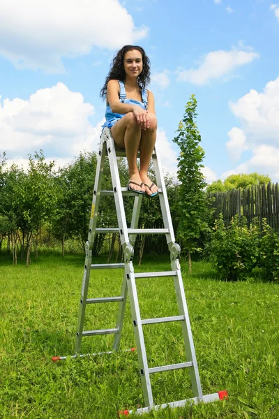 Woman on a ladder in garden — Stock Photo, Image