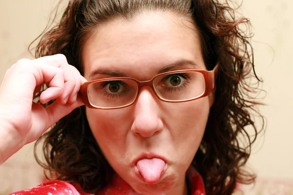 Donna in occhiali che mostra la lingua — Foto Stock
