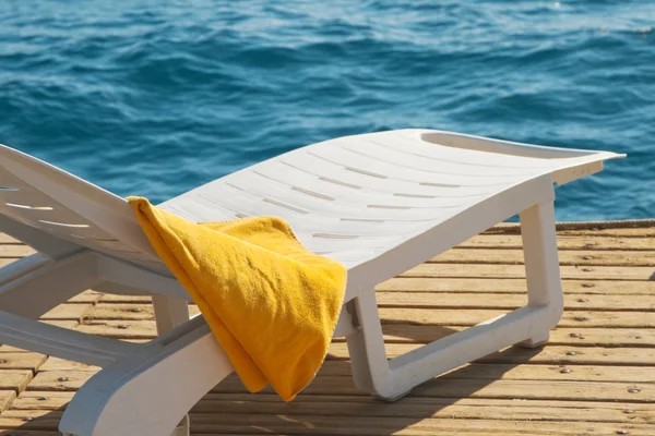 Yellow towel on lounge chair — Stock Photo, Image
