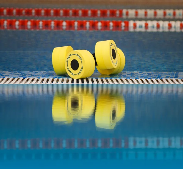 Aqua aeróbica halteres refletidos na água — Fotografia de Stock