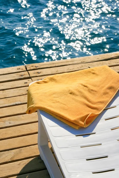 Toalha amarela na cadeira lounge — Fotografia de Stock
