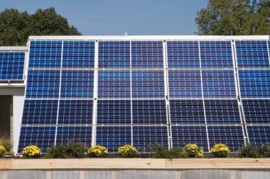 Row of Solar Panels on Roof Against Blue Sky clipart