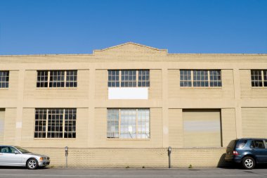 Exterior of Old Warehouse, Street, Parked Cars, Blue Sky clipart