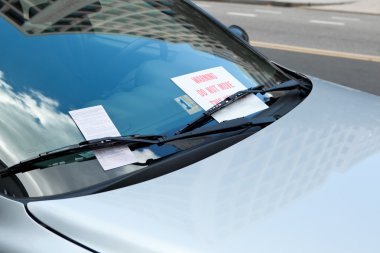 Park cezası cam sileceği altında araba, uyarı işareti