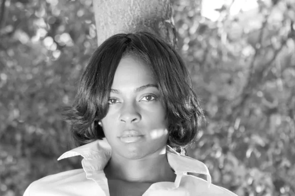 Afrikanische Amerikanerin lehnt Baum schwarz weiß — Stockfoto