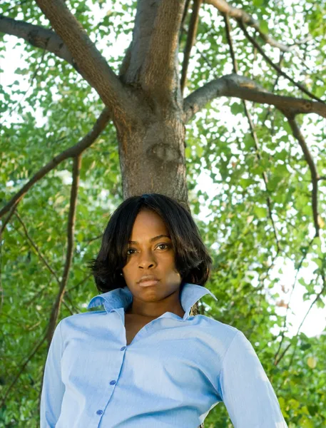Pouting afro-américaine femme penchant arbre — Photo