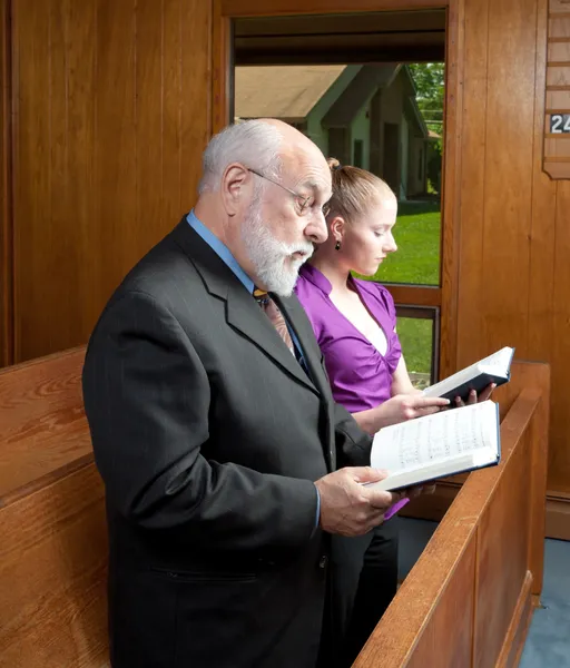 Älterer Mann junge Frau steht in Kirche und singt Gesangbücher — Stockfoto