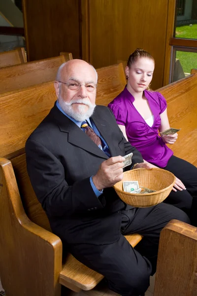 Oudere man jonge vrouw kerk aanbod doneren — Stockfoto
