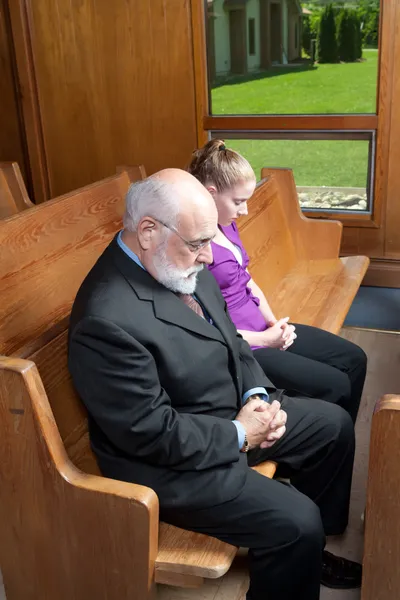 Senior Mann junge Frau gebeugt Köpfe beten Kirche — Stockfoto