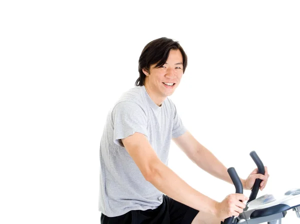 Усміхнений азіатський чоловік на вправі велосипед в одязі — стокове фото